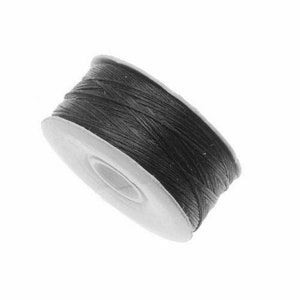 May include: A spool of black thread for sewing or crafting.
