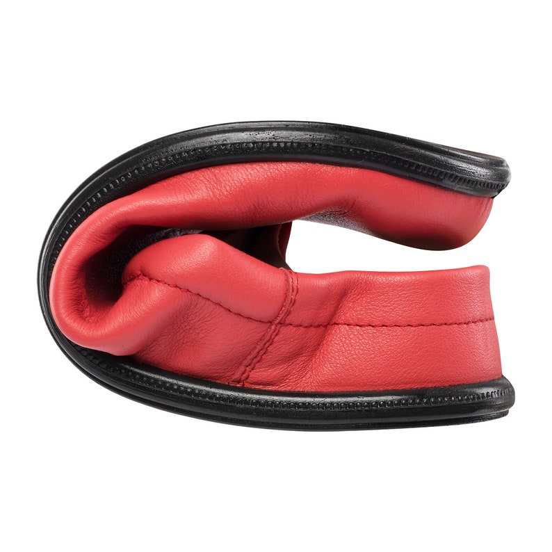 May include: Red leather slip-on shoes with a black rubber sole. The shoes are folded in half, showing the inside of the shoe.