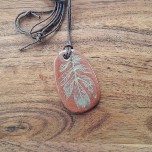 Difusor colgante de terracota con diseño de hoja verde bebé.