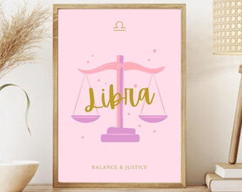 May include: A framed pink Libra zodiac sign art print. The artwork features a scale illustration with the word "Libra" in gold script. The text "Balance & Justice" is below the scale. The print is displayed on a wooden shelf with decorative items.