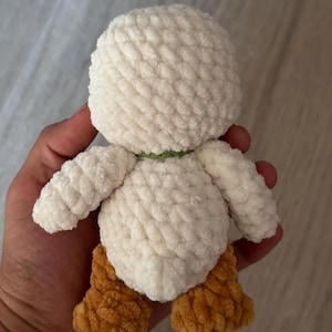 May include: A handmade, plush duck toy with a white body, brown feet, and a green neck band. The soft, textured material gives the duck a cuddly appearance. This adorable toy is perfect for children or as a decorative item.