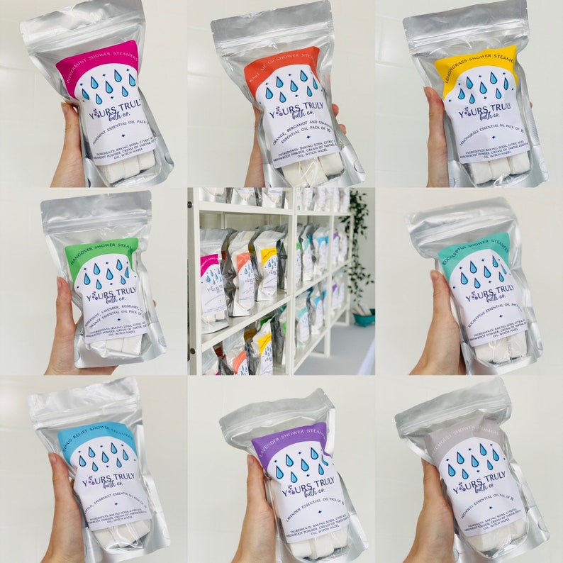 May include: A selection of shower steamers in clear plastic bags, each with a different scent and colour. The bags are labelled with the text "Yours Truly Bath Co." and the scent of each steamer. The steamers are displayed on a shelf.