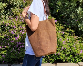 Waxed canvas tote bag with leather handles and round bottom