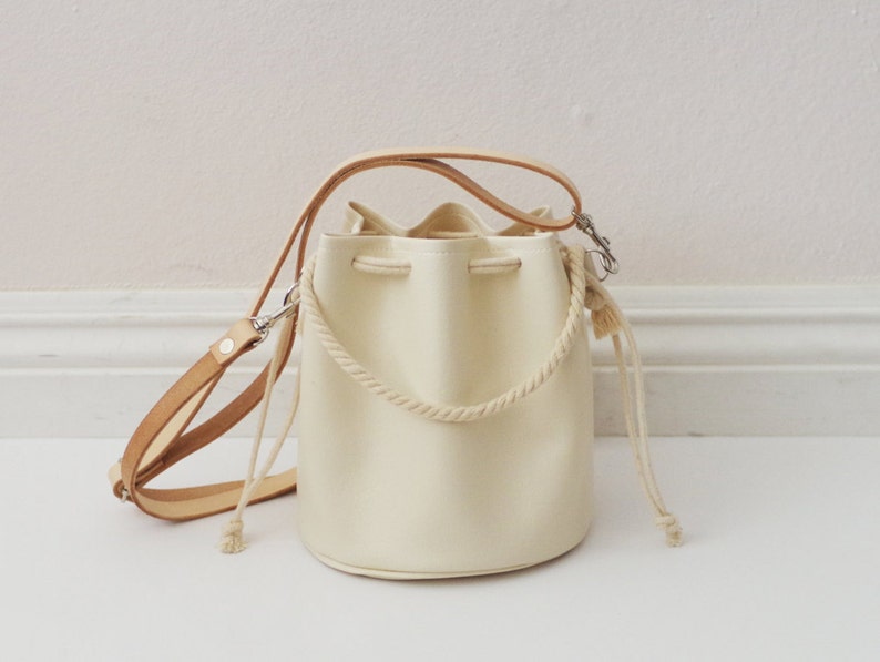 Mini faux leather drawstring crossbody bucket bag with veg tan leather straps 