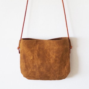 Small brown waxed canvas crossbody bag with round leather straps