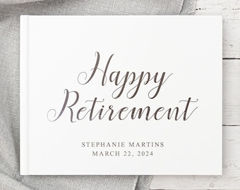 May include: White hardcover guest book with the text "Happy Retirement" in cursive script. The book is personalized with the name "Stephanie Martins" and the date "March 22, 2024".