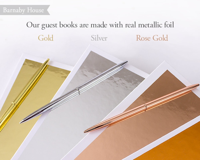 May include: Three pens on a white surface, each pen is on a different colored paper. The papers are gold, silver, and rose gold. The text "Our guest books are made with real metallic foil" is above the pens. The text "Gold", "Silver", and "Rose Gold" are below the pens.