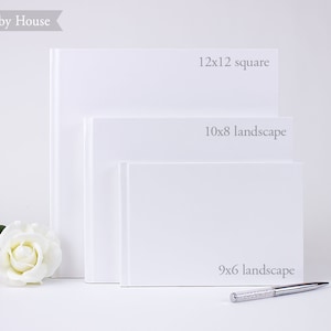 May include: Three white photo albums of different sizes. The largest album is 12x12 inches square, the middle album is 10x8 inches landscape, and the smallest album is 9x6 inches landscape.