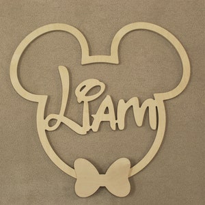 May include: Wooden cutout of Mickey Mouse's head with a bow tie and the name "Liam" written inside.