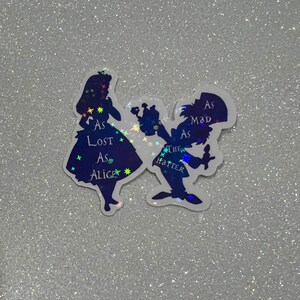 Puede incluir: Pegatinas de silueta de Alicia y el Sombrerero Loco de Alicia en el Pa&iacute;s de las Maravillas. Alicia lleva un vestido azul con el texto "As Lost As Alice" y el Sombrerero Loco lleva un sombrero de copa con el texto "As Mad As The Hatter".