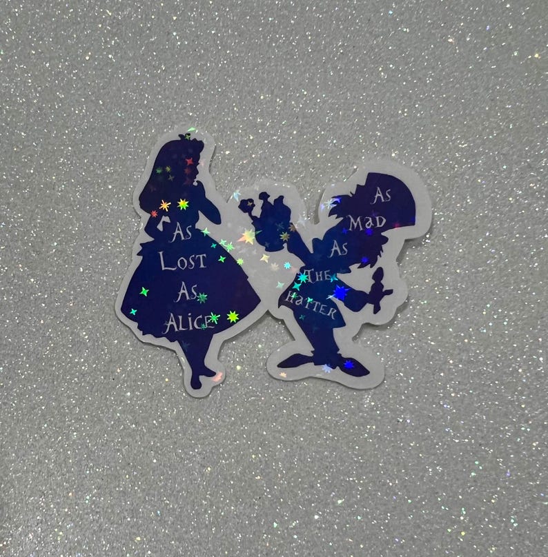 Puede incluir: Pegatinas de silueta de Alicia y el Sombrerero Loco de Alicia en el Pa&iacute;s de las Maravillas. Alicia lleva un vestido azul con el texto "As Lost As Alice" y el Sombrerero Loco lleva un sombrero de copa con el texto "As Mad As The Hatter".