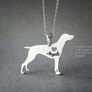 May include: Silver pendant necklace featuring a dog silhouette with a heart cutout and the word "Angels" engraved inside. The pendant is on a silver chain.