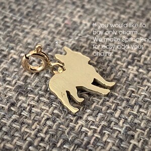 May include: Gold-toned French Bulldog charm with a spring ring for attaching to a chain. The charm is a silhouette of a French Bulldog.
