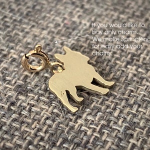 May include: Gold-toned French Bulldog charm with a spring ring for attaching to a chain. The charm is a silhouette of a French Bulldog.