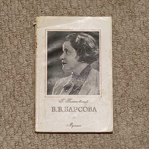 Może przedstawiać: Stara książka z czarno-białym portretem kobiety na okładce. Tytuł jest w języku rosyjskim, ze słowem „Muzyka” na dole. Okładka jest w kolorze złamanej bieli i nosi ślady zużycia.