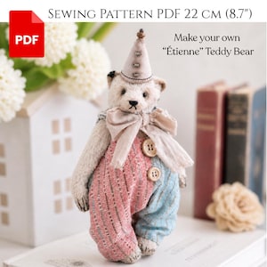 Könnte beinhalten: Ein handgefertigter Teddybär mit einem Clown-Outfit. Der Bär hat einen cremefarbenen Körper, einen rosa-blau gemusterten Overall und einen passenden Hut. Der Text auf dem Bild lautet "Make your own 'Étienne' Teddy Bear". Das Schnittmuster ist 22 cm groß.