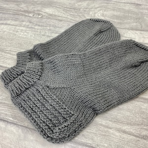May include: A pair of gray knitted socks. The socks are made of a soft, comfortable material and have a simple, classic design.