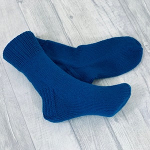 May include: A pair of blue knitted socks. The socks are folded in half and the top of the socks are visible.