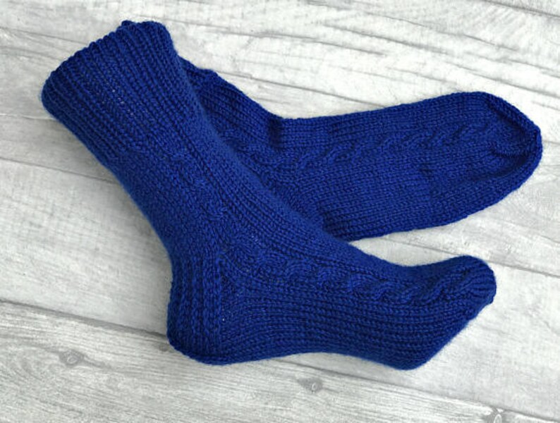 May include: A pair of blue knitted socks with a cable knit pattern.