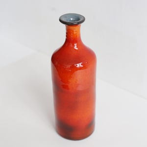 Bouteille rouge vif idéale pour les boissons ou comme décoration d'intérieur