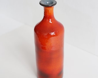 Vibrant red bottle ideal for beverages or as interior decor