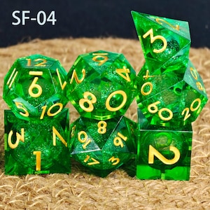 May include: A collection of seven green polyhedral dice with gold numerals. The dice are transparent and faceted, with a glittery interior. The dice are arranged on a textured, brown surface. The text "SF-04" is in the upper left corner.
