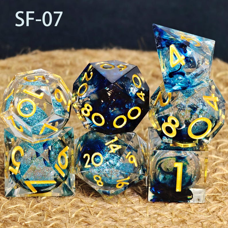 May include: A set of seven polyhedral dice. The dice are clear resin with blue glitter and dark blue accents. The numbers are gold. The text "SF-07" is in the upper left corner. Ideal for tabletop games.