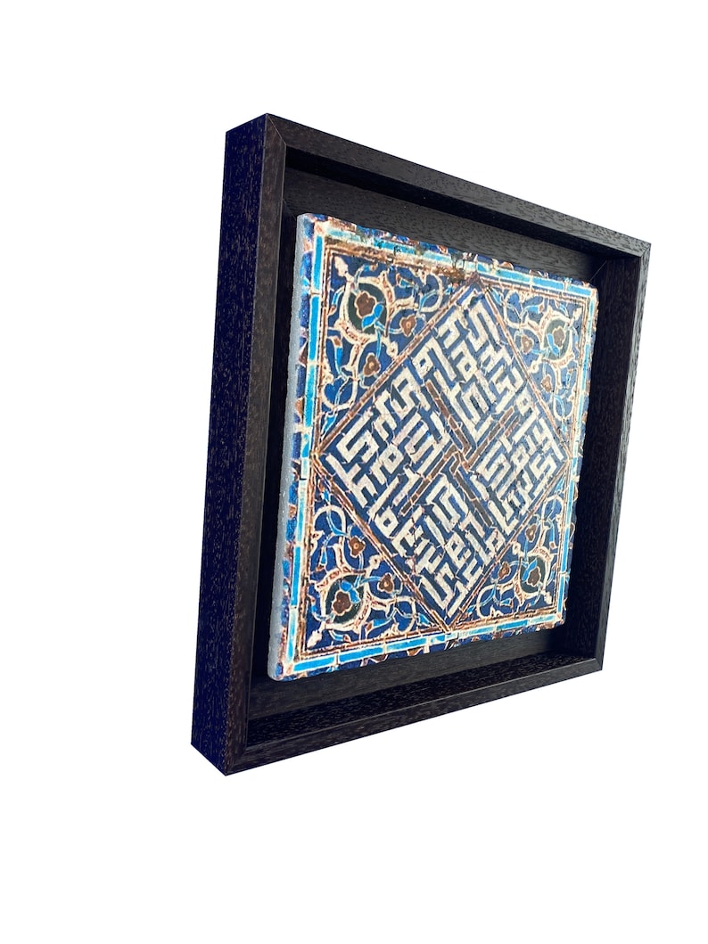 Peut inclure: Un carreau de c&eacute;ramique encadr&eacute; avec un motif g&eacute;om&eacute;trique bleu et blanc. Le carreau pr&eacute;sente des motifs complexes et de la calligraphie arabe.