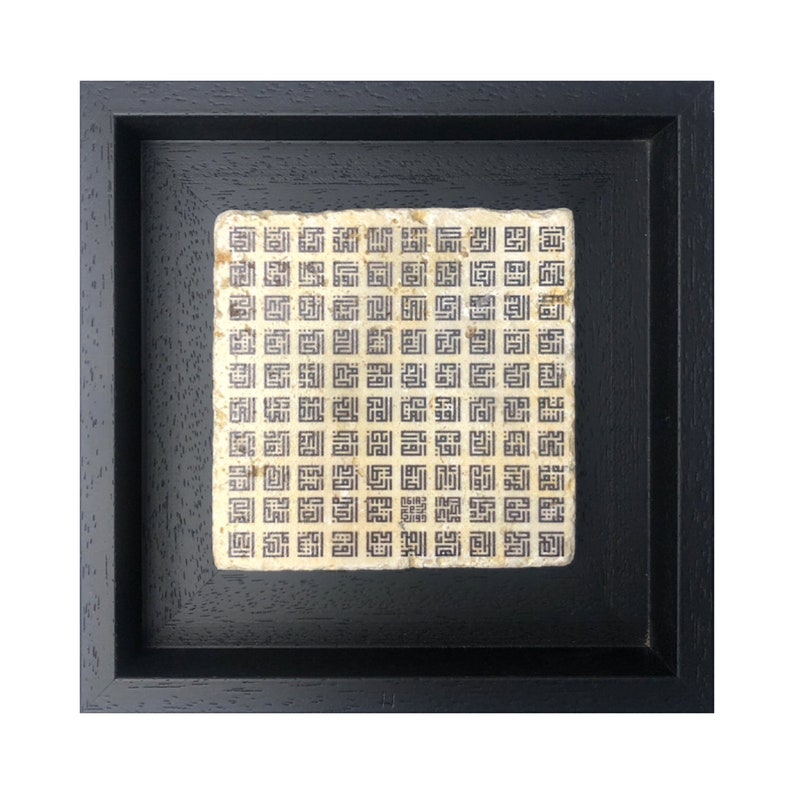 May include: A framed black and white artwork with a repeating pattern of geometric shapes. The artwork is set against a black background.