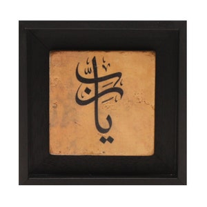 May include: A framed piece of art featuring black calligraphy on a tan background. The calligraphy is in Arabic script.