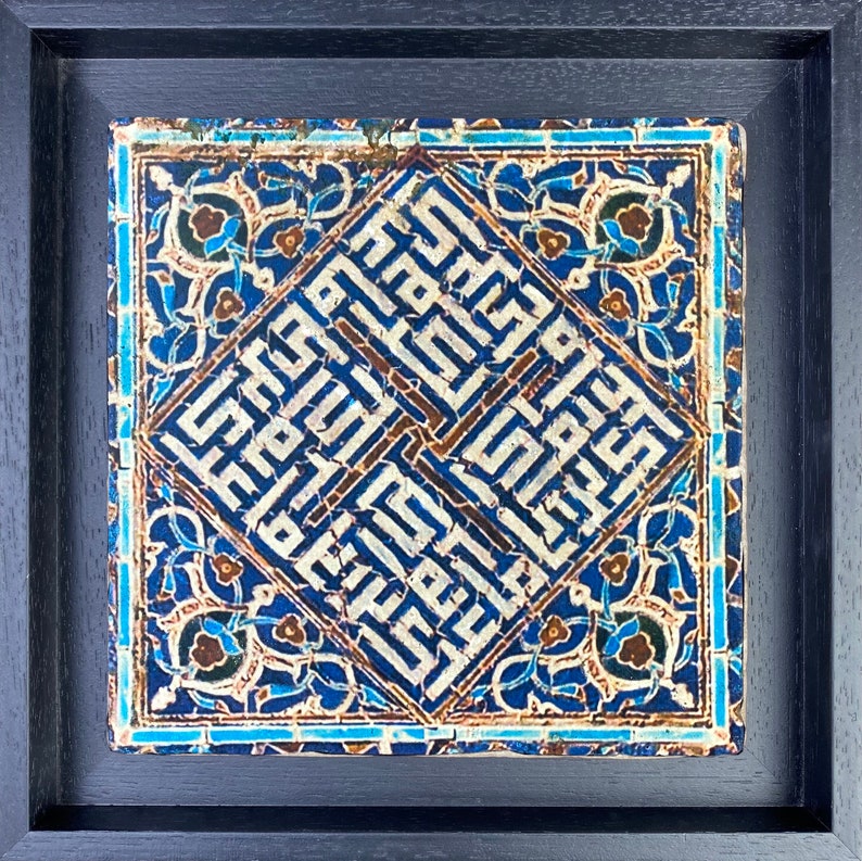 Peut inclure: Un carreau encadr&eacute; avec un fond bleu et une calligraphie blanche complexe en forme de diamant. Le carreau est entour&eacute; d'une bordure de motifs floraux bleus et blancs.