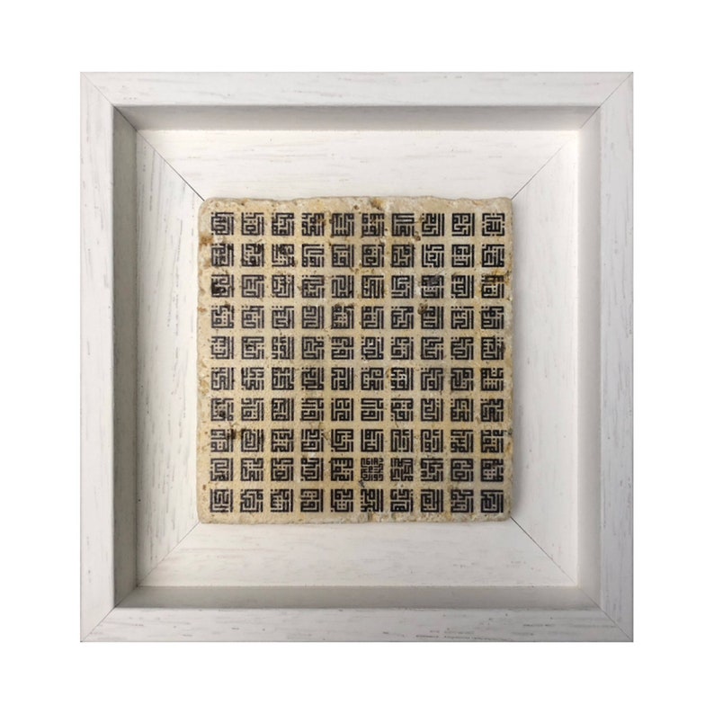 May include: A framed square piece of art with a white frame and a beige background. The art features a repeating pattern of black geometric shapes.