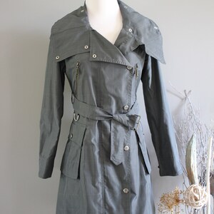 May include: A gray plaid trench coat with a large collar, a belt, and multiple pockets.