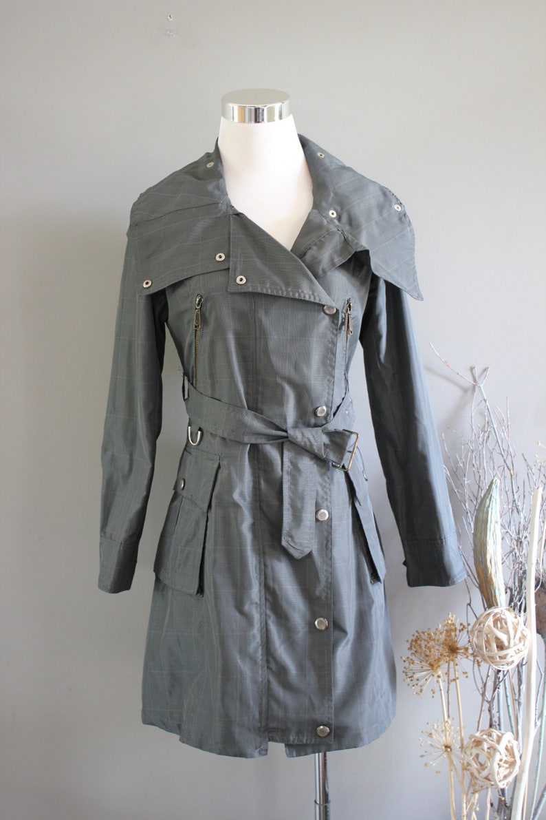 May include: A gray plaid trench coat with a large collar, a belt, and multiple pockets.