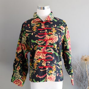 May include: A black floral print jacket with red and yellow accents. The jacket has a mandarin collar and a button closure.