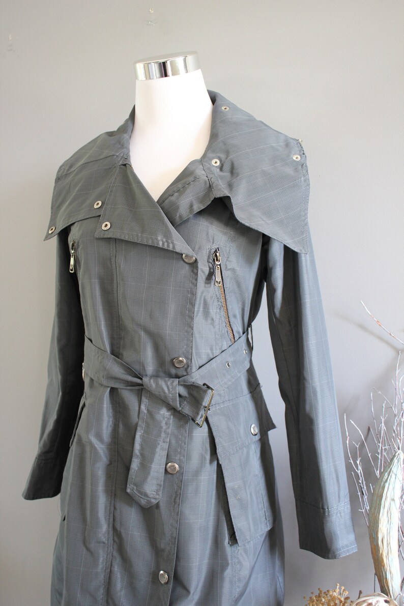 May include: A gray plaid trench coat with a large collar, a belt, and multiple pockets.
