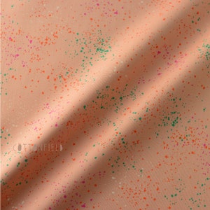 May include: Peach-colored fabric with a splatter pattern in orange, green, pink, and white.