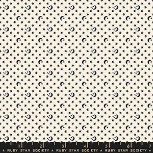 May include: A white fabric with a repeating pattern of black stars and crescent moons. The fabric has a ruler at the bottom with the text "Ruby Star Society" repeated.