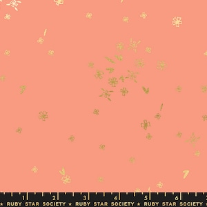May include: Peach-coloured fabric with a scattered pattern of gold glitter flowers. The fabric is marked with a ruler in inches and the text "RUBY STAR SOCIETY".
