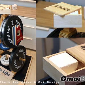 May include: A wooden chalk box with a hinged lid and the word "Chalk" engraved on the top. The box is sitting on a weight plate stand with other weight plates. The stand is made of wood and has the words "Lifting is Life" written on the bottom.