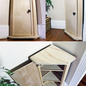 May include: A light wood corner cabinet with a single door and three shelves. The cabinet is open and the shelves are visible.