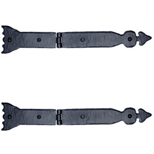 May include: Two black metal hinges with decorative pointed ends and a serrated edge on one side. The hinges are closed and ready to be installed.