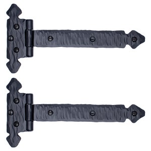 May include: Two black iron strap hinges with decorative arrowhead ends. The hinges are designed for heavy doors and have a hammered finish.