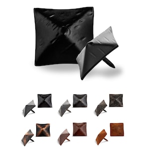 May include: Assortment of square-shaped nail head tacks in various finishes, including black, brown, and copper. The tacks have a pyramid-shaped top and a pointed bottom.