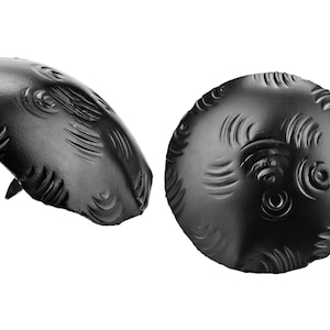 May include: Two black metal decorative nail heads with a textured, circular design. The nail heads have a raised, rounded center and a flat base.