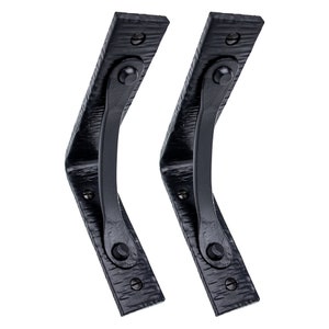 May include: Two black metal shelf brackets with a decorative curved design. The brackets are made of wrought iron and have a hammered finish.