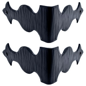 Puede incluir: Dos soportes de esquina de metal negro con un dise&ntilde;o decorativo ondulado. Los soportes est&aacute;n hechos de metal texturizado y tienen un acabado ligeramente desgastado.