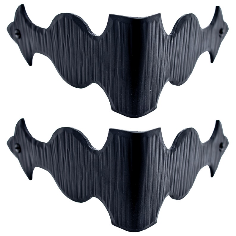Puede incluir: Dos soportes de esquina de metal negro con un dise&ntilde;o decorativo ondulado. Los soportes est&aacute;n hechos de metal texturizado y tienen un acabado ligeramente desgastado.