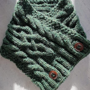 May include: A dark green knitted cowl with a cable knit pattern and two brown wooden buttons.