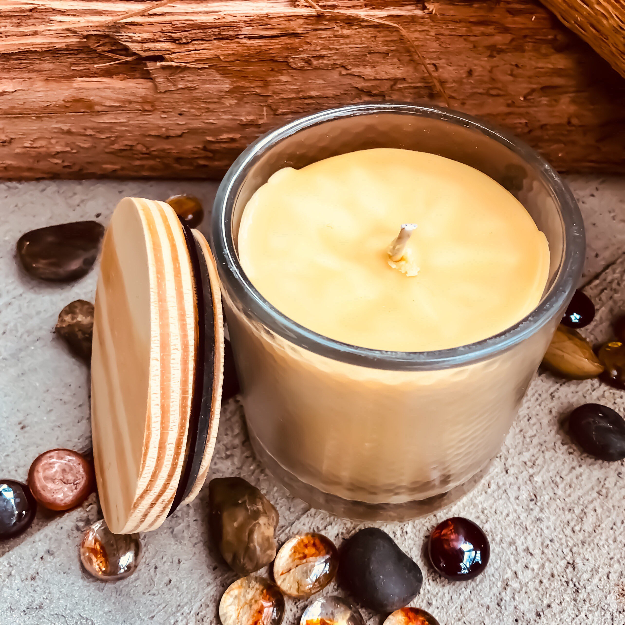 Pure organic beeswax candle in a large glass jar topped with wooden lid
